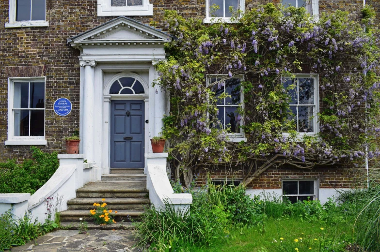 a house with a blue sign in front of it, inspired by Prince Hoare, pexels contest winner, arts and crafts movement, lilac bushes, mary delany, external staircases, architectural digest photo