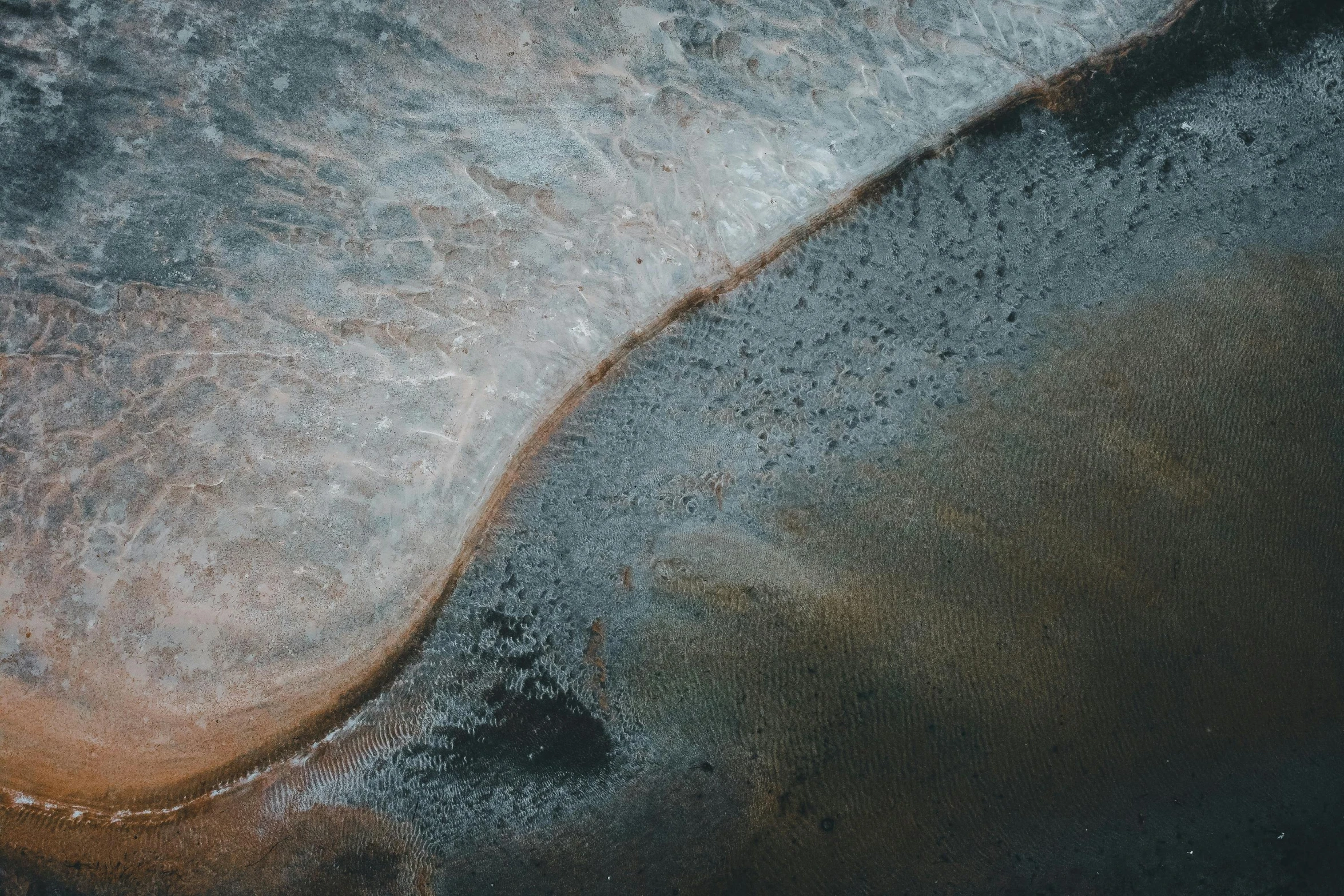 an aerial view of a body of water, a microscopic photo, by Neil Blevins, trending on pexels, dust and sand in the air, half turned around, oily puddles, looking to the right