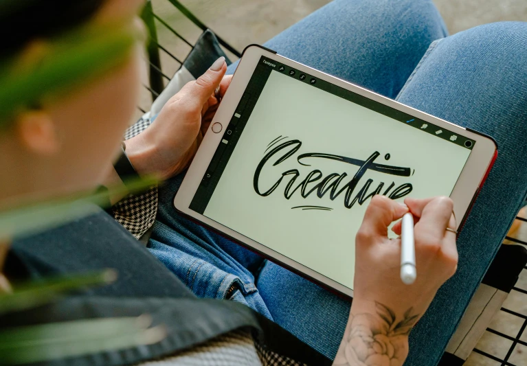 a person writing on a tablet with a pen, a cartoon, trending on pexels, estrange calligraphy, 9 9 designs, very artistic pose, indi creates