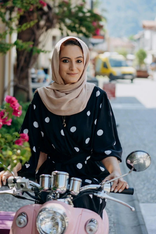 a woman riding on the back of a pink scooter, inspired by Maryam Hashemi, renaissance, looks directly at camera, polka dot, riding a motorbike, square