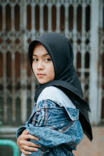 a woman in a hijab poses for a picture, by Basuki Abdullah, trending on unsplash, hurufiyya, teenage boy, square, with black, half body photo