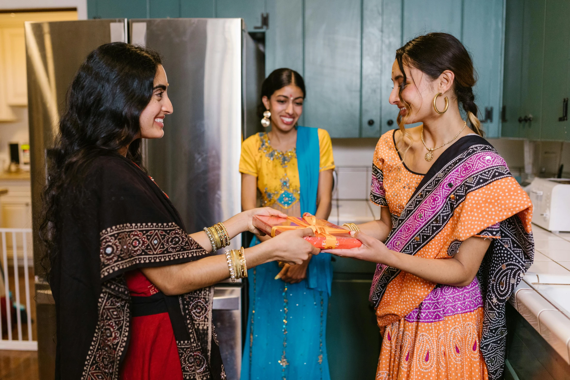 a group of women standing next to each other in a kitchen, pexels contest winner, hurufiyya, holding gift, hindu aesthetic, profile image, thumbnail