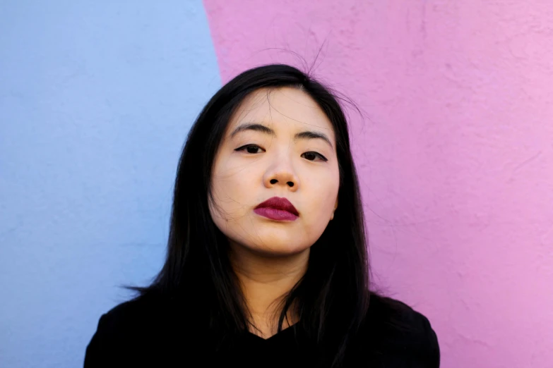a woman standing in front of a pink and blue wall, an album cover, inspired by Kim Tschang Yeul, unsplash, pouty lips, portrait n - 9, engineer, standing with a black background
