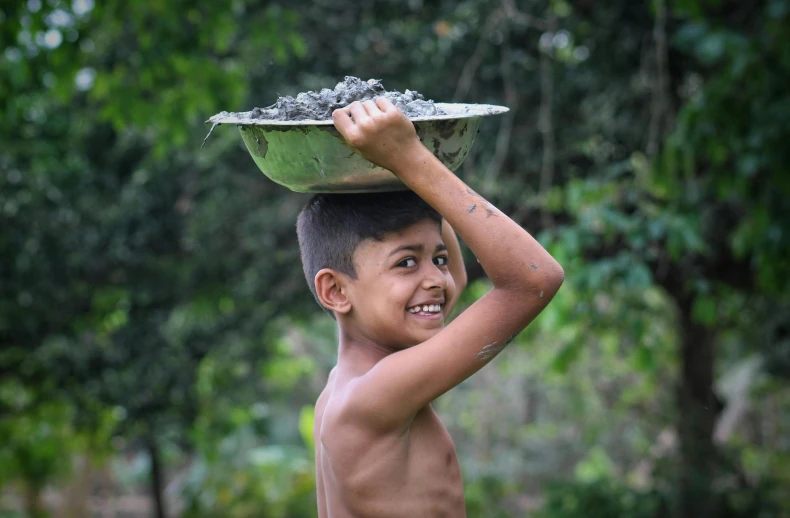 a young boy carrying a bowl on his head, pexels contest winner, sumatraism, coal, of a shirtless, a still of a happy, avatar image