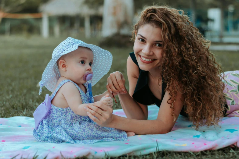 a woman laying on top of a blanket next to a baby, pexels contest winner, attractive girl, 15081959 21121991 01012000 4k, in the park, square