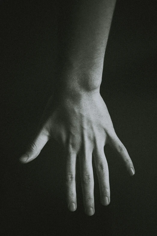 a black and white photo of a person's hand, inspired by Robert Mapplethorpe, unsplash, hyperrealism, ilustration, instagram post, woman, low light