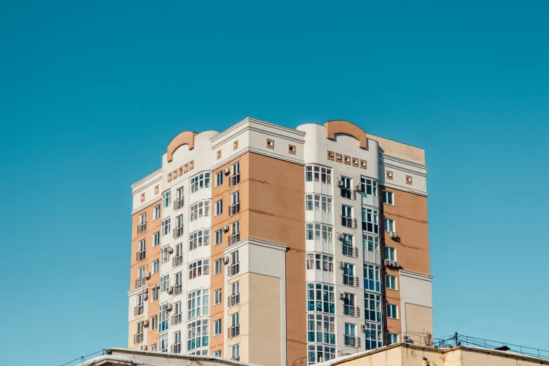 a tall building with a clock on top of it, pexels contest winner, soviet apartment building, clear blue skies, 000 — википедия, brown