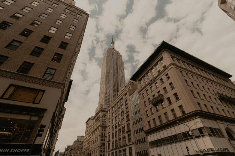 a very tall building towering over a city, unsplash contest winner, neoclassicism, new york streets, brown, 2000s photo, slide show