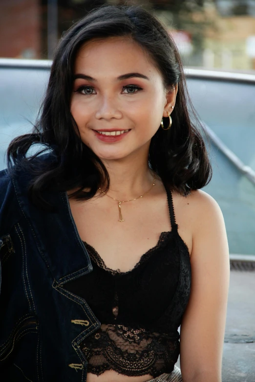 a woman posing for a picture in front of a car, by Robbie Trevino, wearing black camisole outfit, south east asian with round face, 1 9 year old, black hair