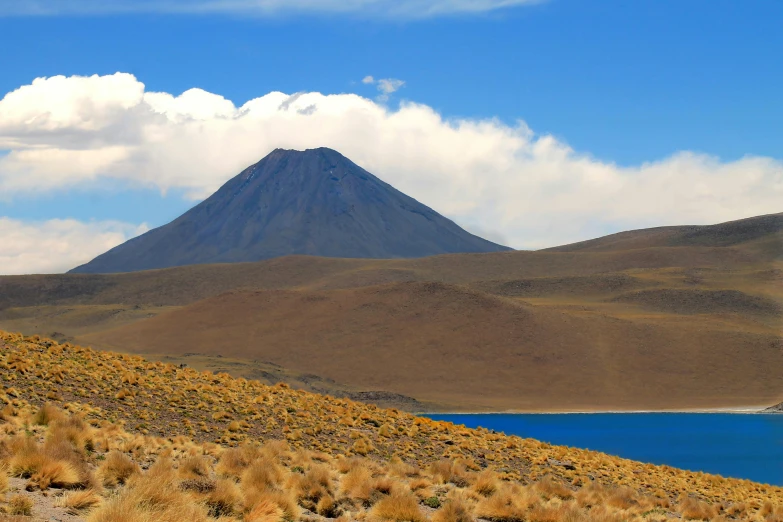 a mountain in the distance with a lake in the foreground, a photo, hurufiyya, avatar image, in chuquicamata, slide show, mount doom