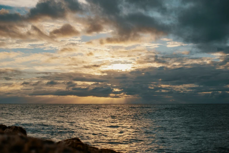 a large body of water under a cloudy sky, a picture, by Robbie Trevino, unsplash, australian tonalism, golden hour 8k, seaview, golden hour closeup photo, shot on sony a 7