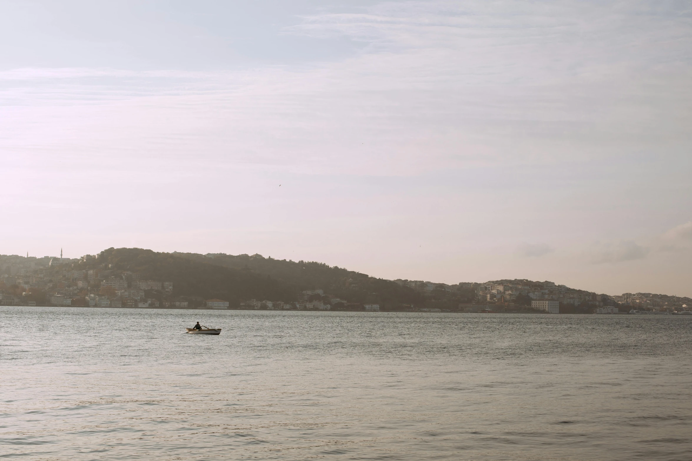 a boat floating on top of a large body of water, by Daniel Seghers, lisbon, slight haze, manly, person in foreground