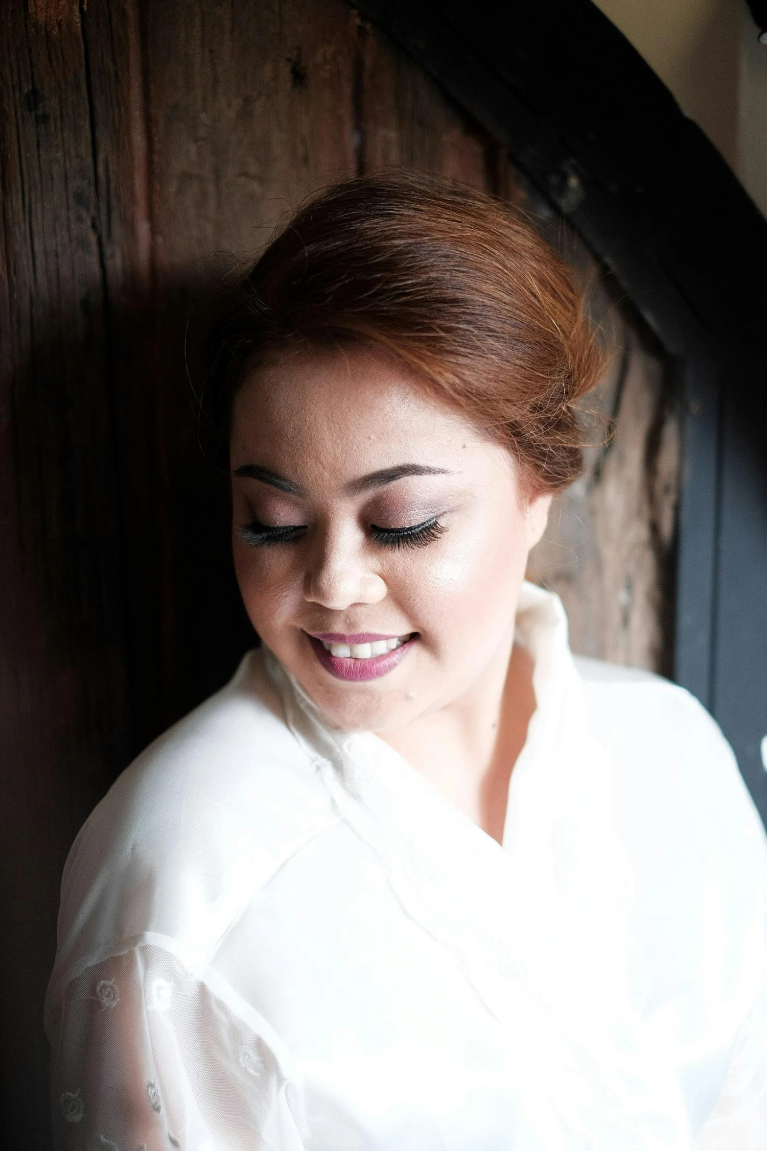 a woman in a white shirt looking at a cell phone, a portrait, inspired by Ruth Jên, pexels contest winner, traditional makeup, bride, south east asian with round face, album cover