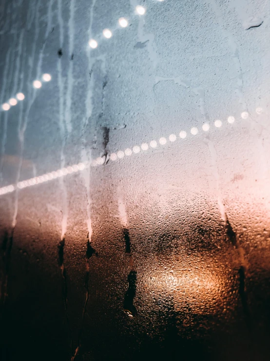 a close up of a window with rain on it, an album cover, inspired by Elsa Bleda, unsplash contest winner, light and space, reflecting light in a nightclub, trending on vsco, light lines, taken in the late 2000s