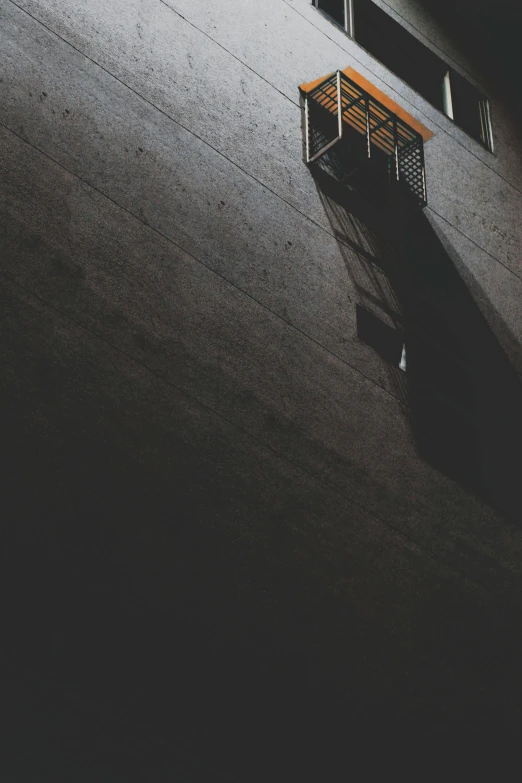 a wooden bench sitting on the side of a building, inspired by Elsa Bleda, pexels contest winner, conceptual art, in the dark elevator, dark grey and orange colours, takato yomamoto, splash image