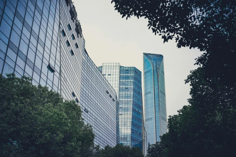 a couple of tall buildings sitting next to each other, inspired by Cheng Jiasui, pexels contest winner, mexico city, glass buildings, low quality photo, fan favorite