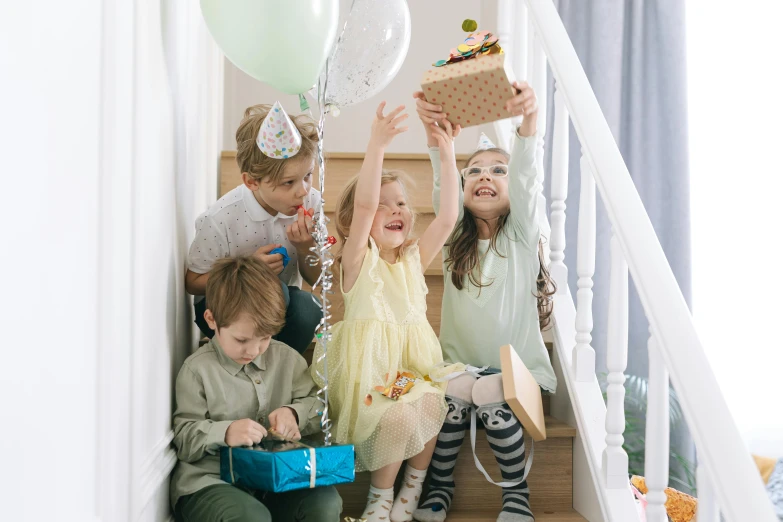 a group of children sitting on a set of stairs, by Emma Andijewska, pexels, figuration libre, birthday wrapped presents, throwing cards in the air, 1 5 0 4, small