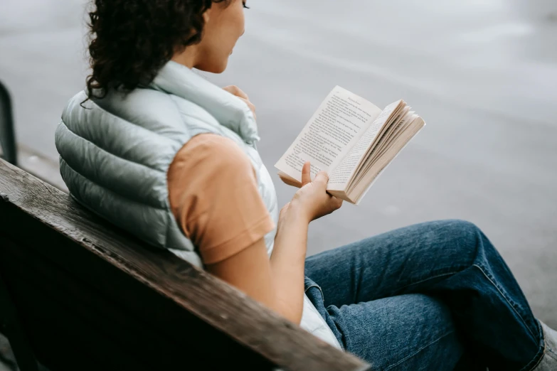 a woman sitting on a bench reading a book, pexels contest winner, pictured from the shoulders up, full product shot, close up half body shot, from waist up
