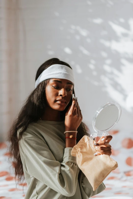 a woman talking on a cell phone while sitting on a bed, trending on pexels, renaissance, brown skin. light makeup, green facemask, with a mirror, slightly pixelated