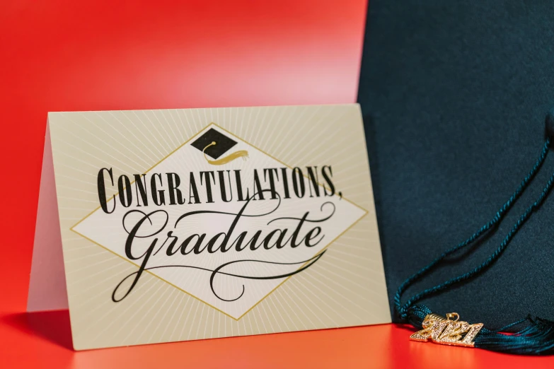 a graduation card with a tassel on top of it, by Julia Pishtar, pexels contest winner, academic art, sign, background image, close - up studio photo, various items