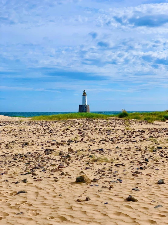 a lighthouse sitting on top of a sandy beach, hammershøi, profile image, multiple stories, guide