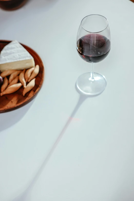 a person sitting at a table with a plate of food and a glass of wine, glass refraction, crimson fork, detailed product shot, standing sideways