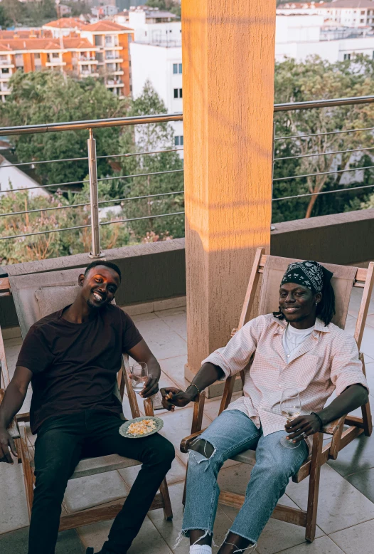 a couple of men sitting on top of a balcony, an album cover, by Ingrida Kadaka, pexels contest winner, mc ride, lounge, smiling at each other, ( ( theatrical ) )