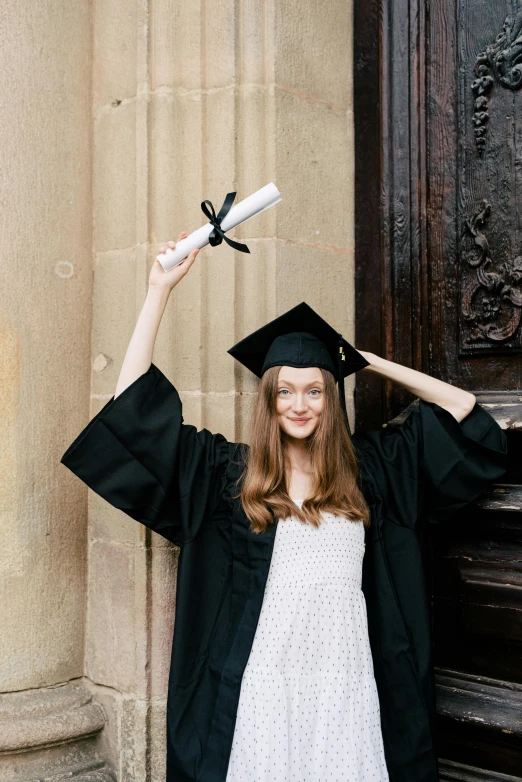 a woman in a graduation gown holding a diploma, by Helen Stevenson, outfit photograph, 1x, white regal gown, black