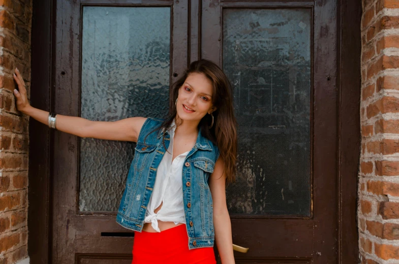 a beautiful young woman standing in front of a door, pexels contest winner, wearing a jeans jackets, with a red skirt, avatar image, ukrainian girl