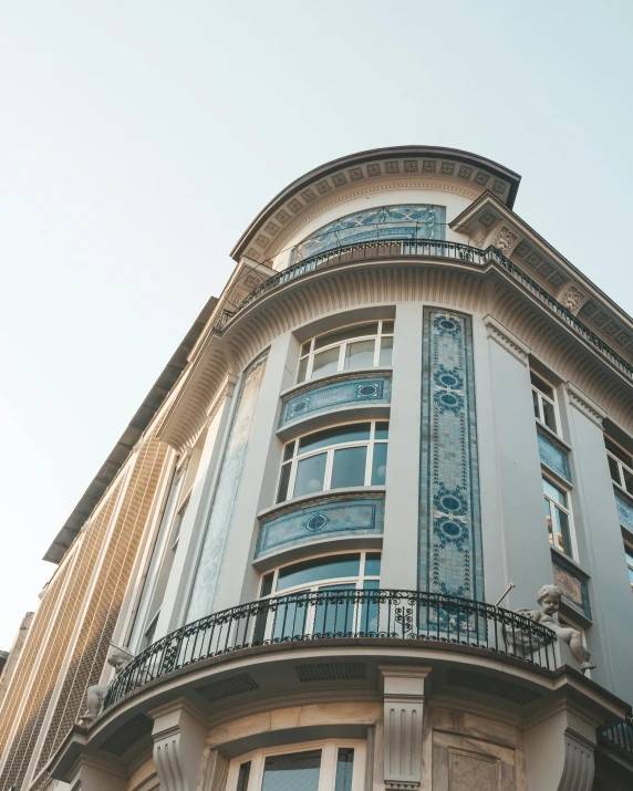 a tall building with lots of windows and balconies, an art deco painting, unsplash contest winner, art nouveau, romanian heritage, blue and gray colors, spanish, art nouveau”