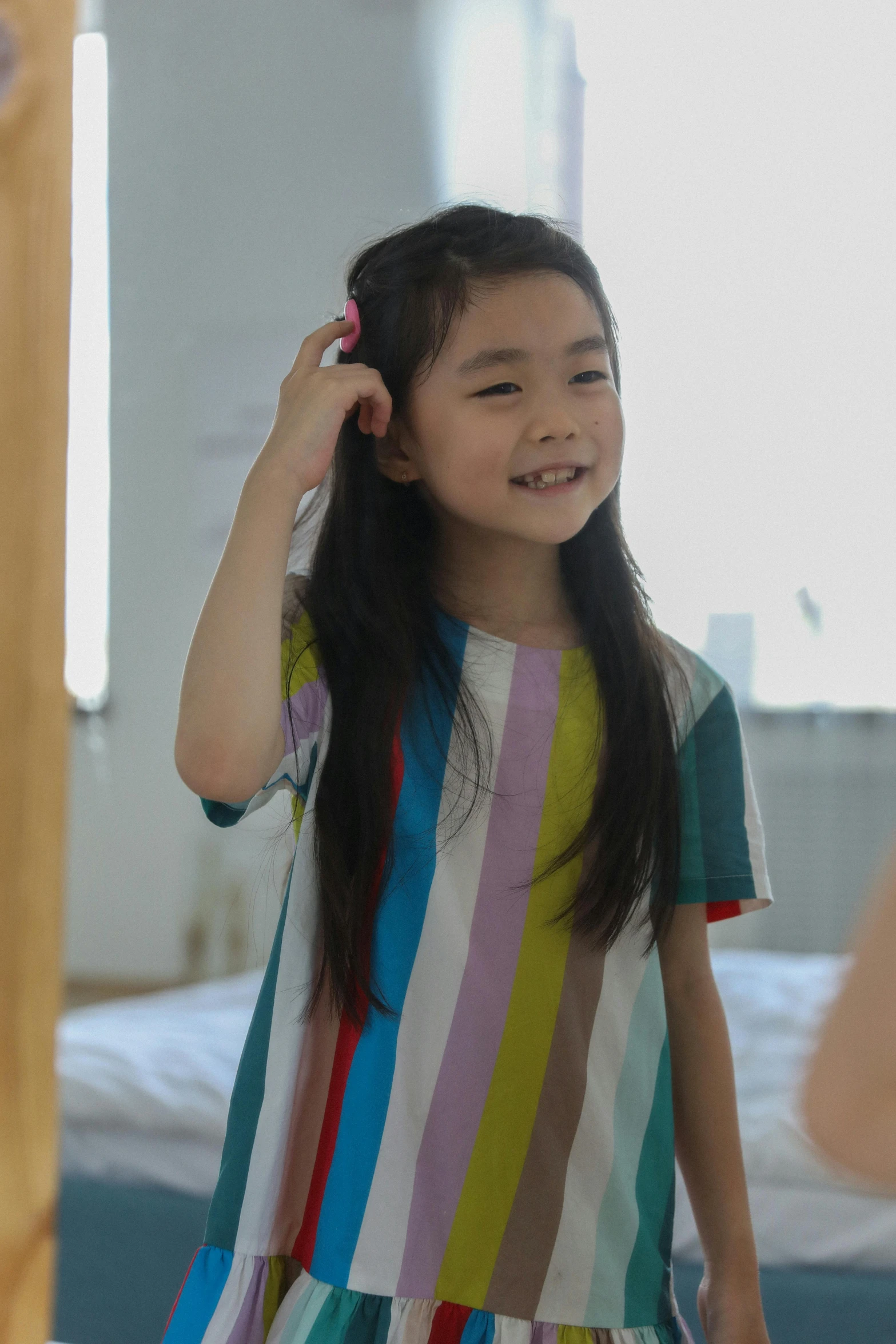 a little girl brushing her hair in front of a mirror, inspired by Hikari Shimoda, pexels contest winner, striped shirt, multicoloured, ( ( theatrical ) ), lee ji - eun