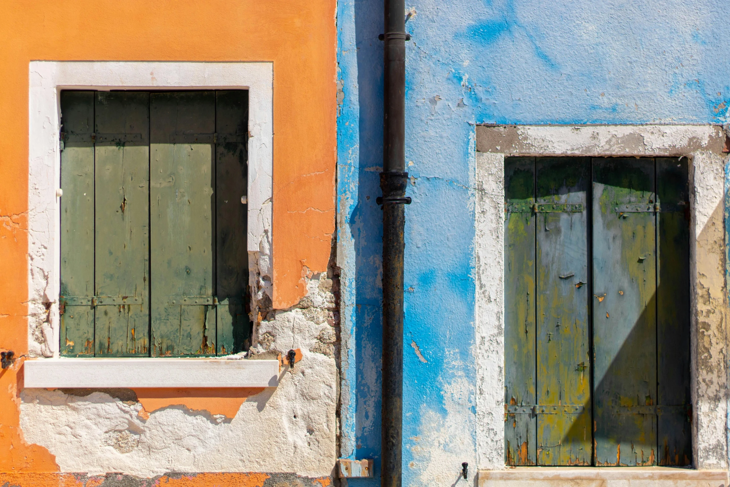 a couple of windows sitting on the side of a building, inspired by Steve McCurry, pexels contest winner, post-impressionism, chartreuse and orange and cyan, venice biennale, “derelict architecture buildings, leaning on door