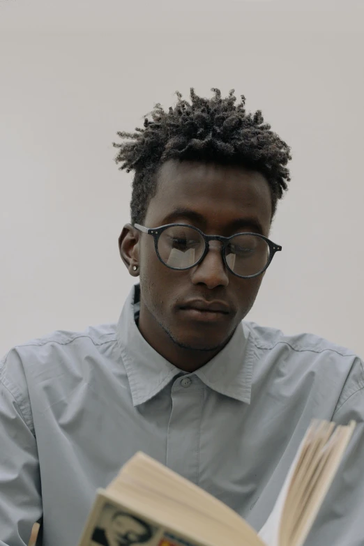 a man sitting at a table reading a book, an album cover, inspired by Barthélemy Menn, trending on unsplash, visual art, ashteroth, headshot profile picture, serious business, ignant