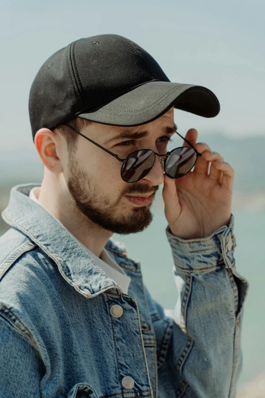 a man wearing a hat and sunglasses talking on a cell phone, inspired by Dan Smith, trending on pexels, discord profile picture, young greek man, wearing a jeans jackets, profile image