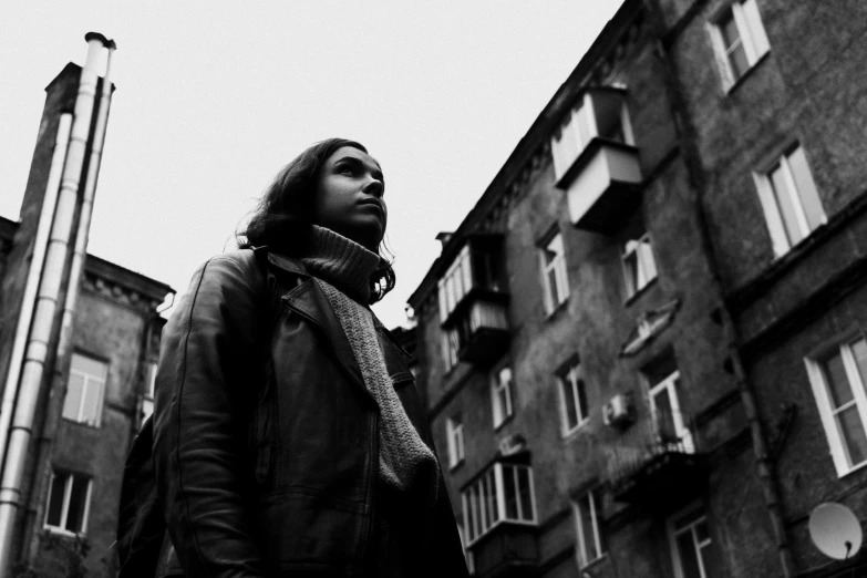 a woman standing in front of a tall building, a black and white photo, antipodeans, andrey surnov, young man, frank dillane, homemade