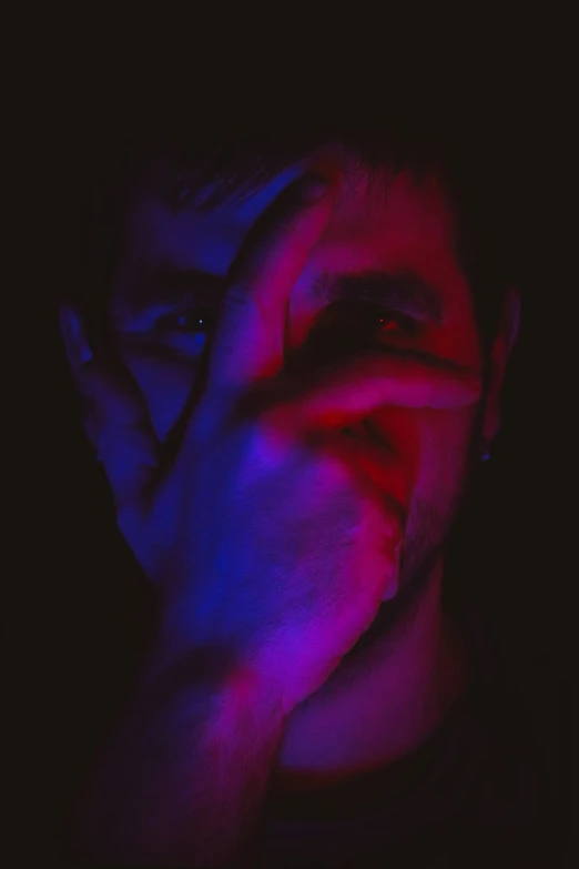 a man covering his face with his hands, an album cover, aestheticism, red blue purple black fade, avatar image, !!! colored photography, neonlights