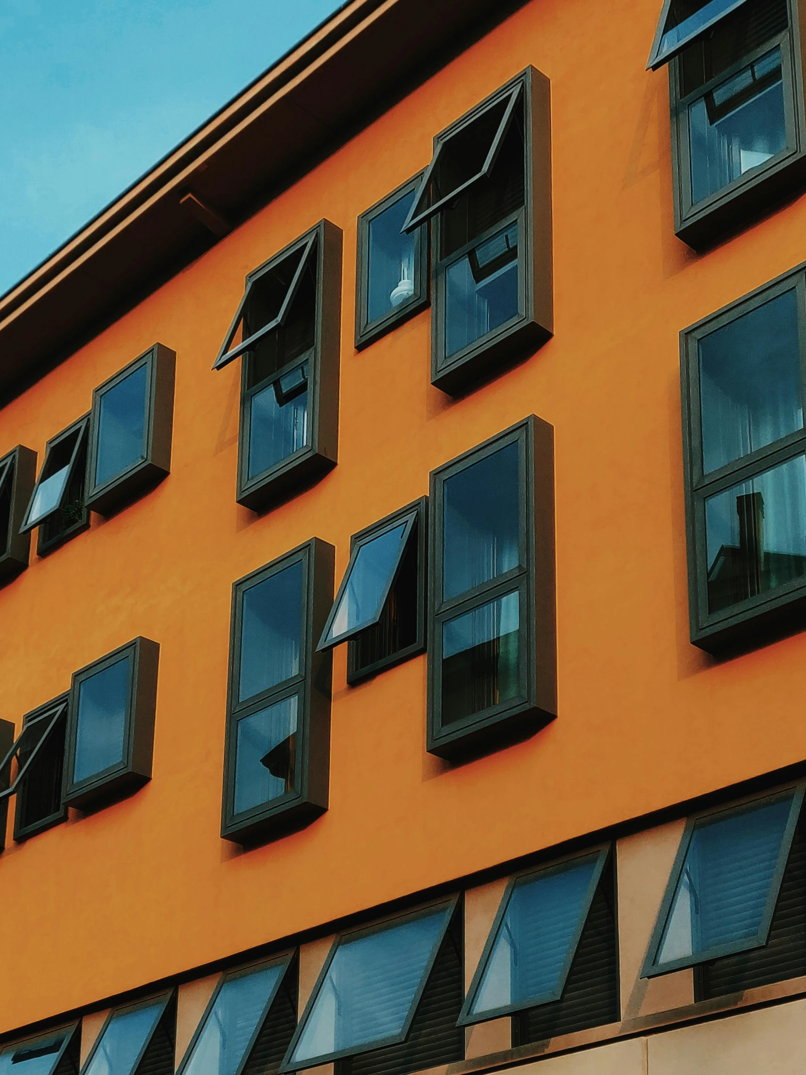 a close up of a building with many windows, by Kristian Zahrtmann, pexels contest winner, orange and black, awnings, hotel room, thumbnail