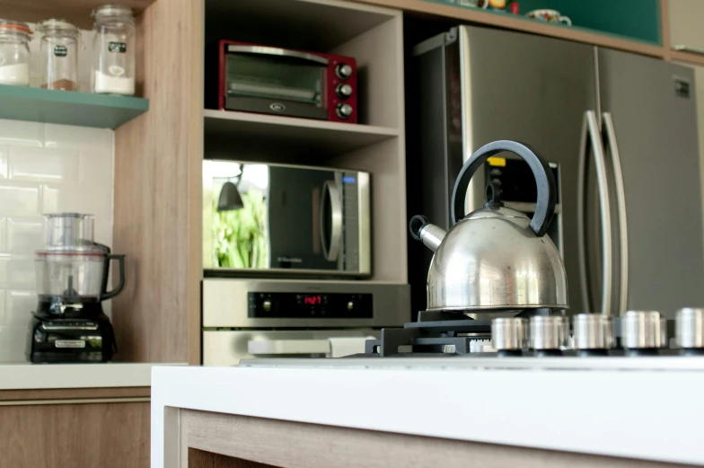 a tea kettle sitting on top of a stove in a kitchen, by Felipe Seade, kitchenette and conferenceroom, eco, television, são paulo