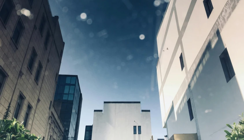 a couple of buildings that are next to each other, a picture, inspired by Richard Wilson, unsplash, bauhaus, light reflection, gopro photo, high quality upload, low - angle shot