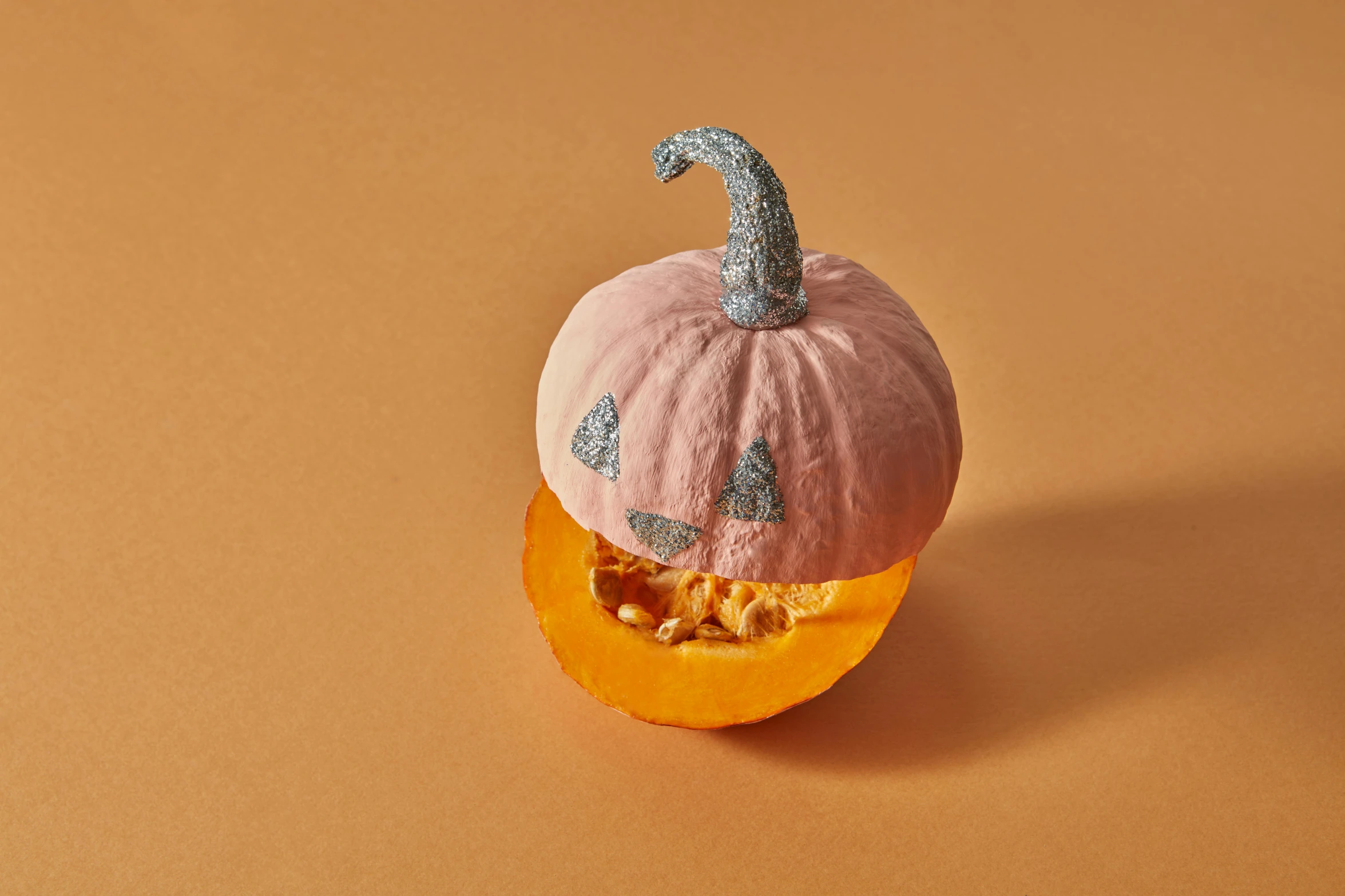 a stuffed pumpkin sitting on top of a piece of fruit, a pastel, inspired by Sarah Lucas, trending on pexels, layered paper, glitter, textured base ; product photos, pareidolia