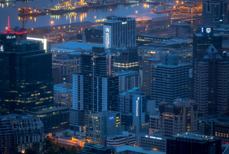 an aerial view of a city at night, by Lee Loughridge, pexels contest winner, wellington, highrise business district, low detail, blue rim lighting