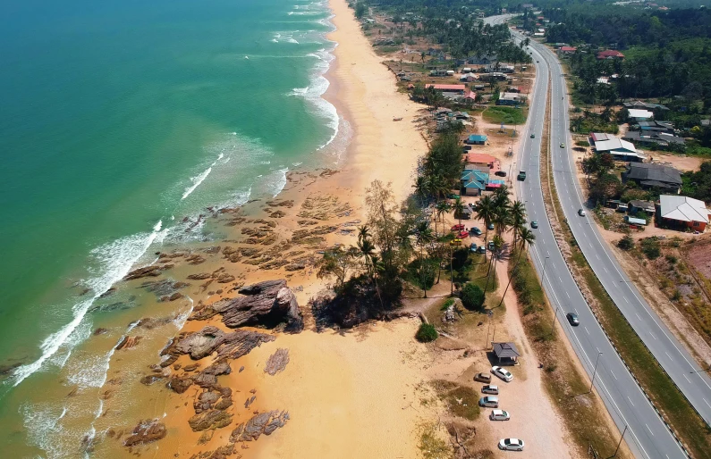 an aerial view of a beach next to the ocean, hurufiyya, sri lankan mad max style, houses and roads, thumbnail, malaysian