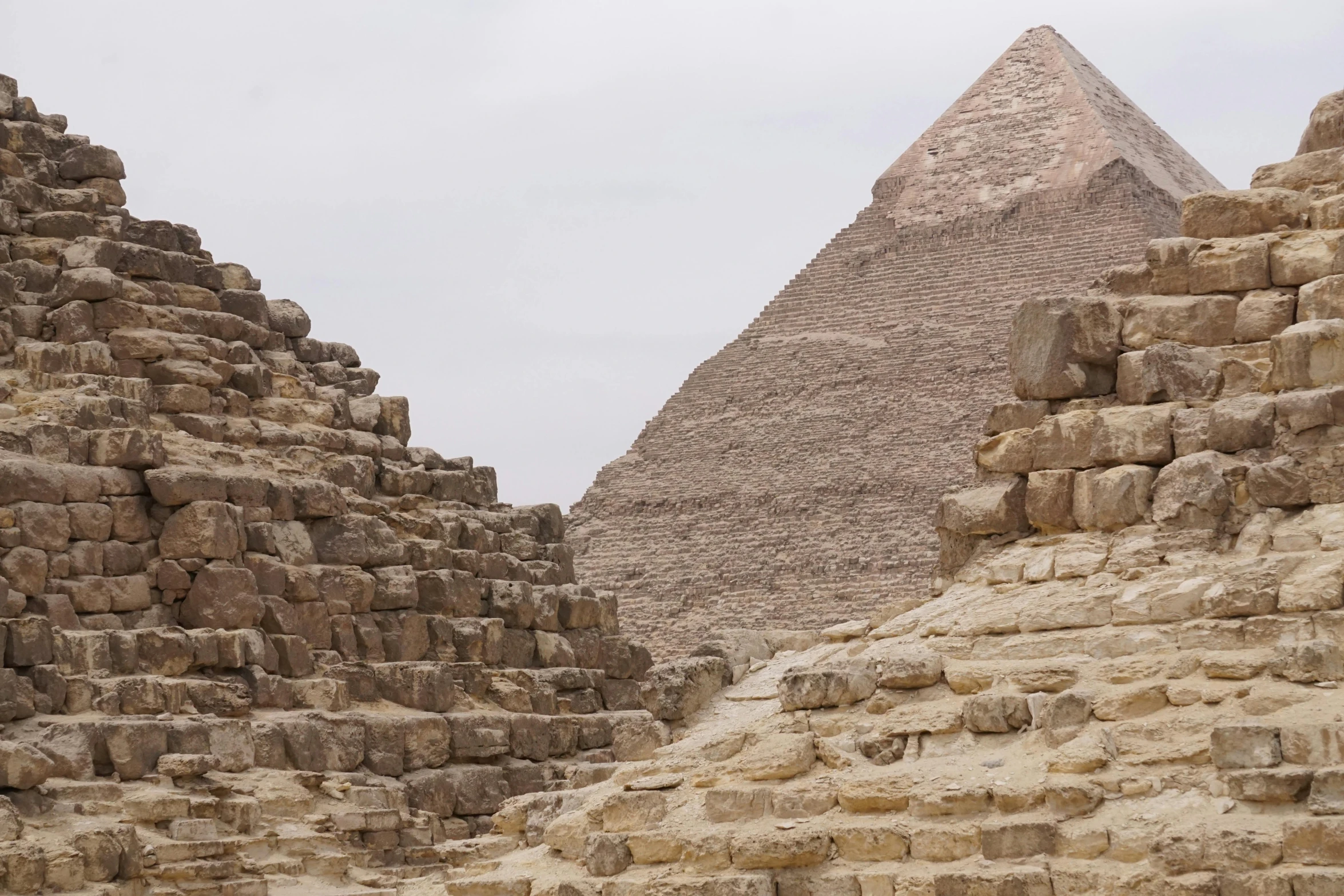 a group of people standing in front of a pyramid, background image, fan favorite, monumental structures, up close