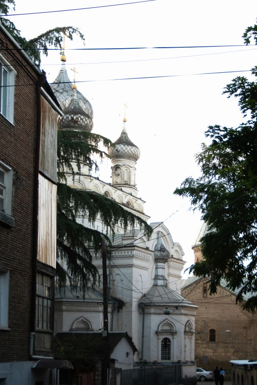 a couple of buildings that are next to each other, inspired by Illarion Pryanishnikov, baroque, mosque, taken from the high street, candid shot, domes