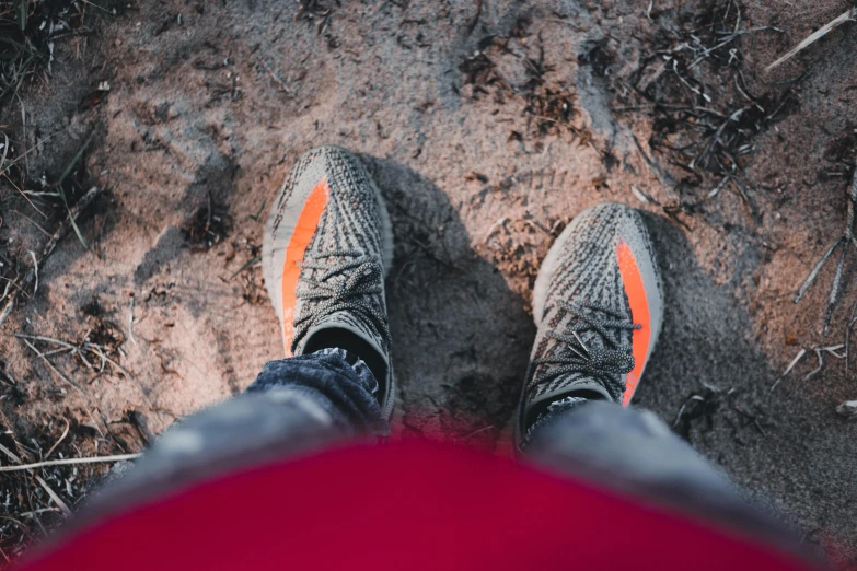 a person standing in the dirt with a red umbrella, yeezy, grey orange, sport, instagram photo