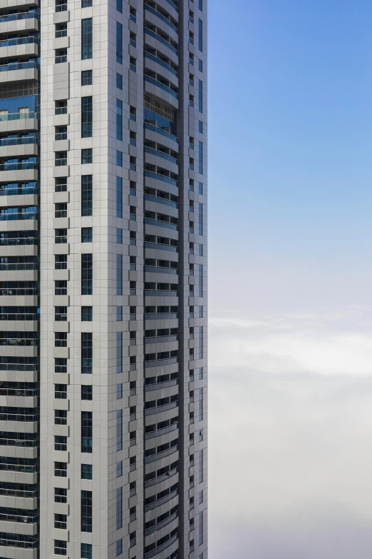 a tall building with lots of windows on top of it, an album cover, inspired by Victor Enrich, pexels contest winner, view above the clouds, exterior wide shot, dubai, high angle uhd 8 k