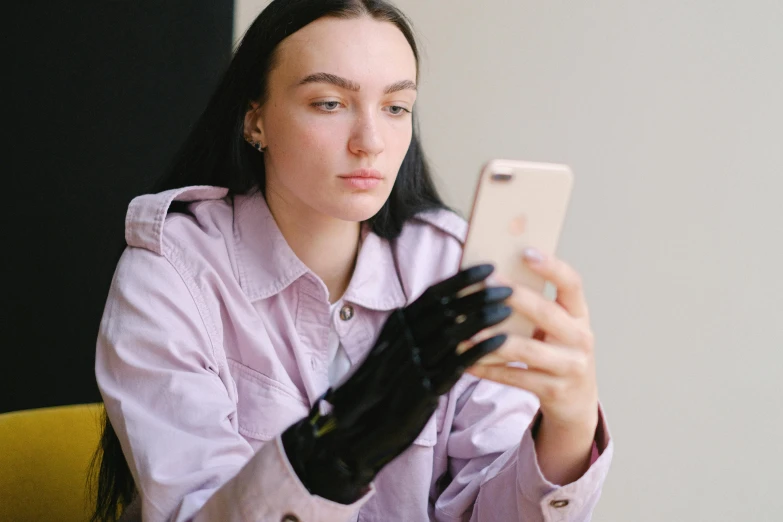 a woman wearing black gloves using her cell phone