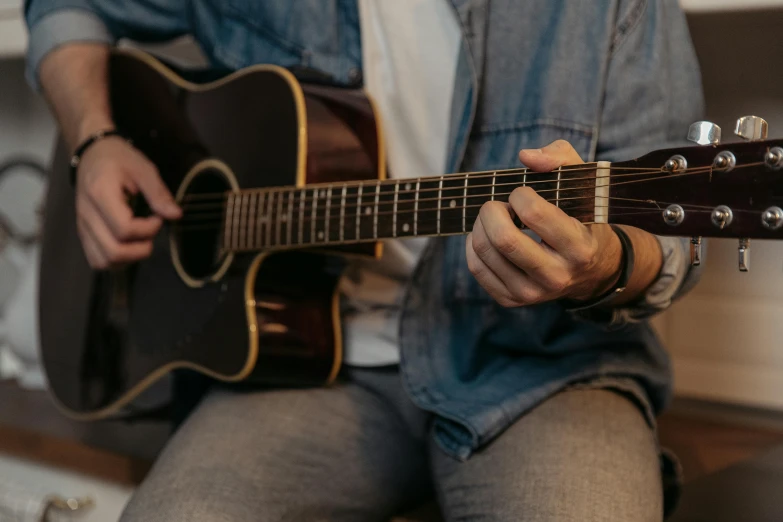 a close up of a person playing a guitar, by Carey Morris, pexels contest winner, lachlan bailey, sitting with wrists together, 15081959 21121991 01012000 4k, instagram post