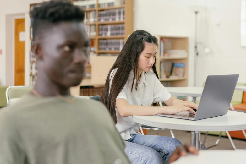 a couple of people sitting at a table with a laptop, by Jang Seung-eop, trending on pexels, academic art, black teenage boy, standing in class, ethnicity : japanese, excel running on the computer