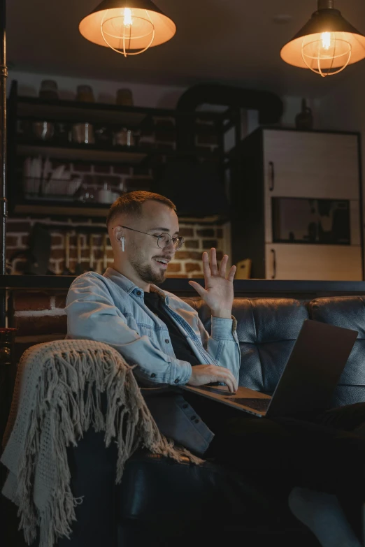 a man sitting on a couch using a laptop, pexels contest winner, waving, avatar image, worksafe. cinematic, evening time